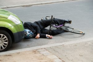 bicycle accident on the street, collision with green car